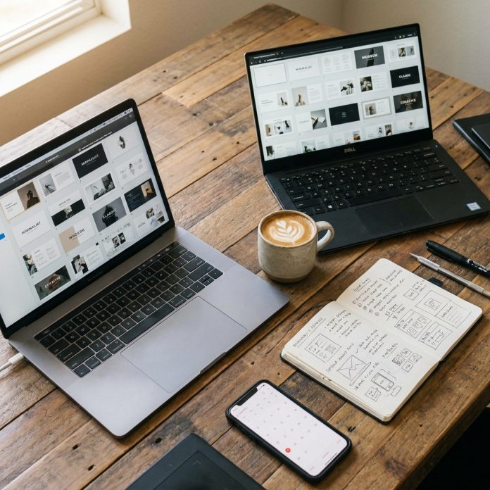 Designer's desk with multiple presentation template thumbnails on laptop screens